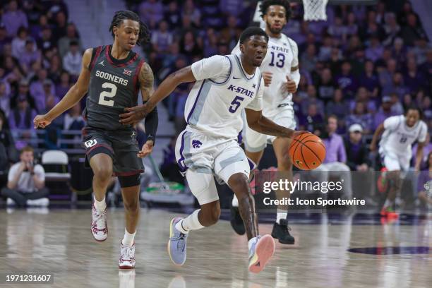 Kansas State Wildcats guard Cam Carter tries to hold off Oklahoma Sooners guard Javian McCollum in the first half of a Big 12 basketball game between...