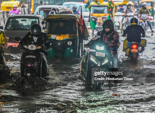 Commuters move through a water logged street after heavy rains lashes out the city at Pandav Nagar Underpass on February 1, 2024 in New Delhi, India.