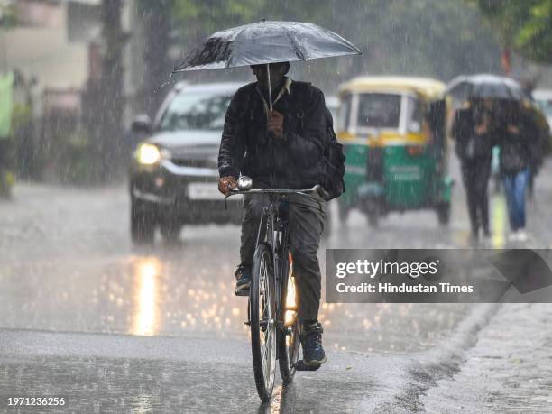 Commuters during light rain in winter, rain increased the severe cold in North India, on February 1, 2024 in Noida, India.