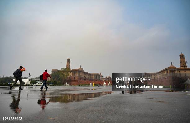 People seen out during light drizzle and cold breeze at Vijay Chowk on February 1, 2024 in New Delhi, India.