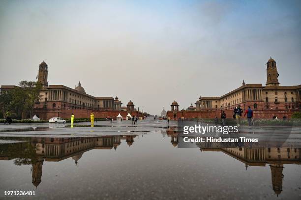 People seen out during light drizzle and cold breeze at Vijay Chowk on February 1, 2024 in New Delhi, India.
