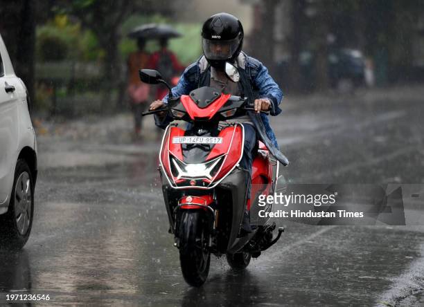 Commuters during light rain in winter, rain increased the severe cold in North India, on February 1, 2024 in Noida, India.