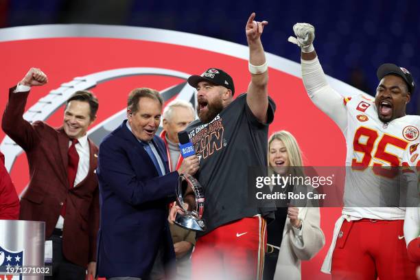 Travis Kelce and Chris Jones of the Kansas City Chiefs celebrate with the Lamar Hunt Trophy as Jim Nantz looks on after a 17-10 victory against the...