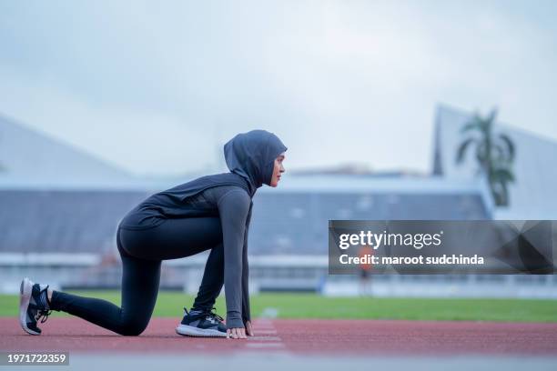 muslim woman sport concept, muslim woman wearing a black hijab is exercising and running at an outdoor - voile religieux photos et images de collection