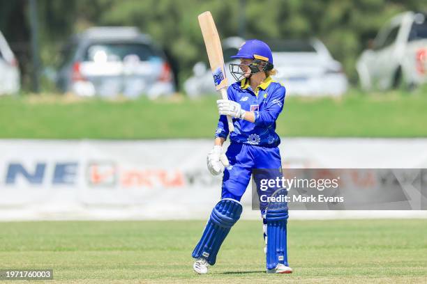 Katie Mack of the Meteors raises her bat in the air after reaching a half century during the WNCL match between ACT and New South Wales at EPC Solar...