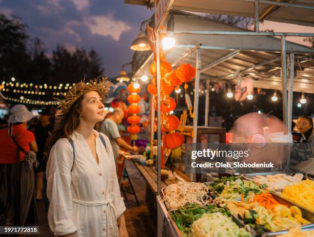 woman choosing food on night market - street food stall stock pictures, royalty-free photos & images