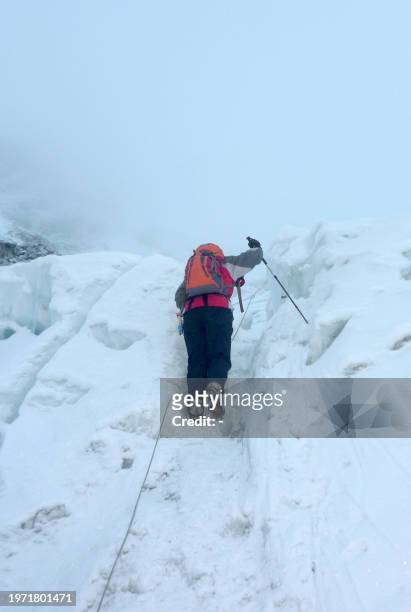 An unidentified mountaineer makes his way up a ridge on Mount Everest on May 11, 2009 Bad weather conditions forced three Nepalese Sherpa brothers to...