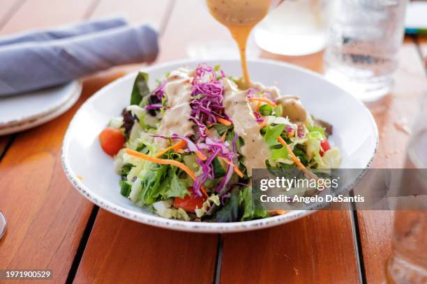 dressing a salad - aliño para la ensalada fotografías e imágenes de stock