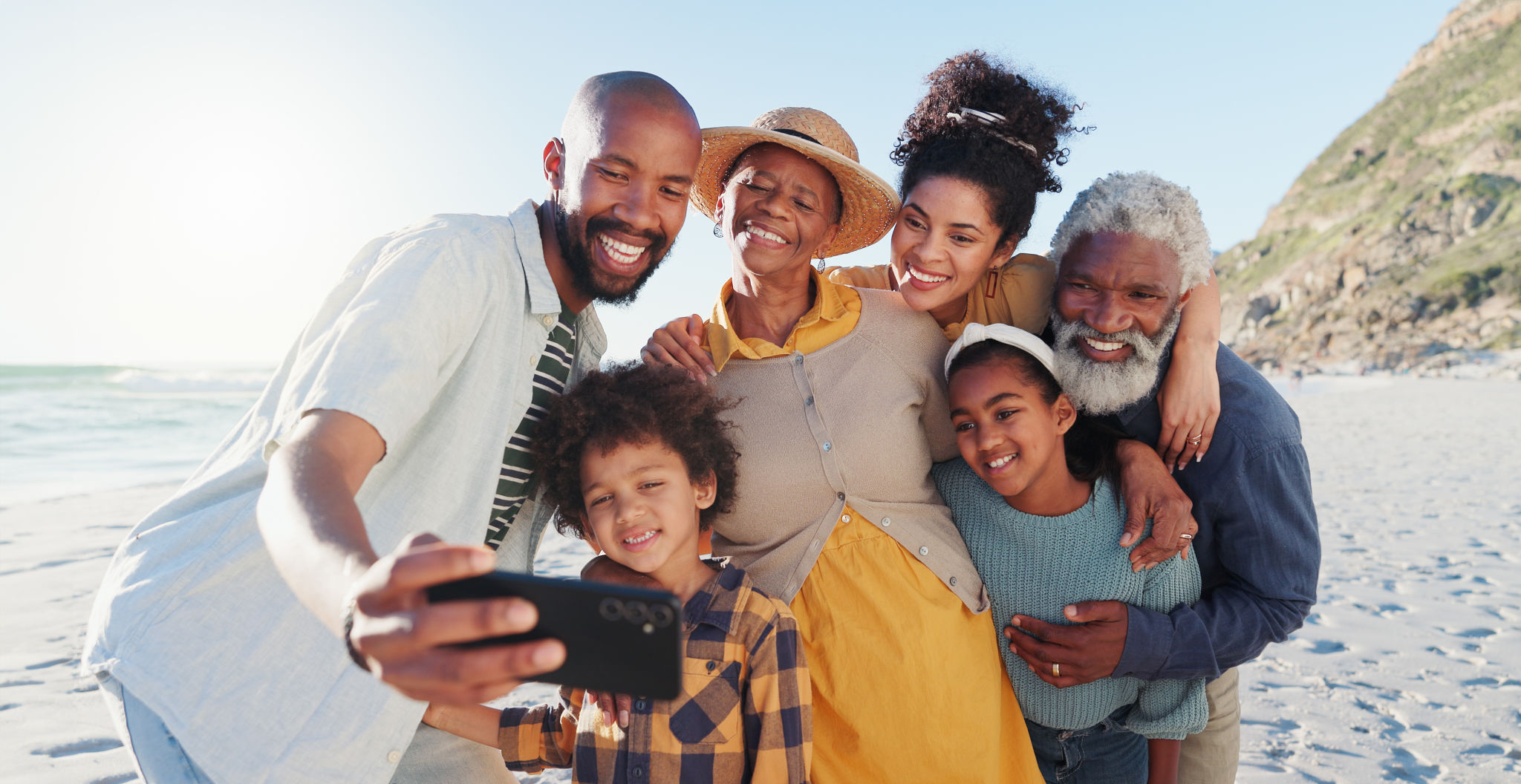 Love, selfie and happy family at a beach for travel, fun or adventure in nature together. Ocean, profile picture and African kids with parents and grandparents at the sea for summer, vacation or trip Love, selfie and happy family at a beach for travel, fun or adventure in nature together. Ocean, profile picture and African kids with parents and grandparents at the sea for summer, vacation or trip