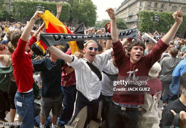 Des supporteurs de l'équipe d'Allemagne manifestent leur joie, le 21 juin 2002 place de l'Hôtel de ville à Paris lors de la retransmission sur un...