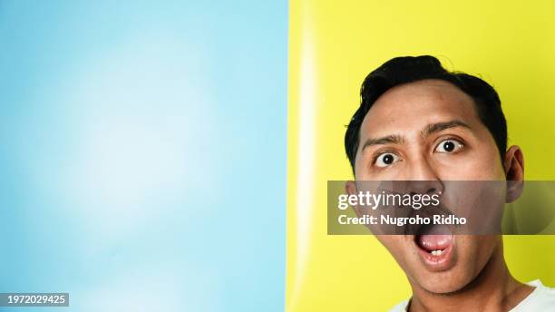 man shocking at the edge of the wall - indonesian faces stock pictures, royalty-free photos & images