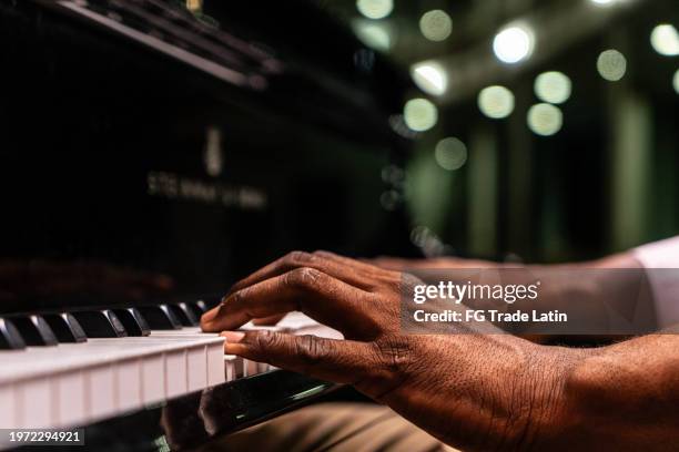 close-up of a man's hand playing piano - piano imagens e fotografias de stock