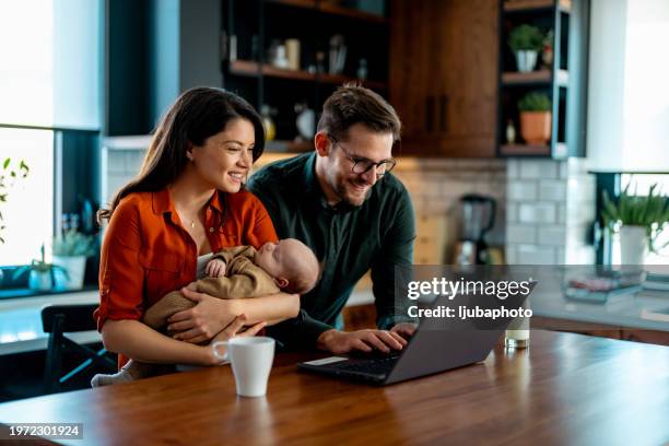 couples allant au-dessus des finances à la maison avec un nouveau-né - jeune famille photos et images de collection