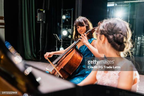 sisters playing piano and cello at stage theater - cuba girls stock pictures, royalty-free photos & images