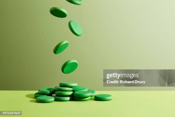coins falling into a heap on a tabletop - green economy stock pictures, royalty-free photos & images