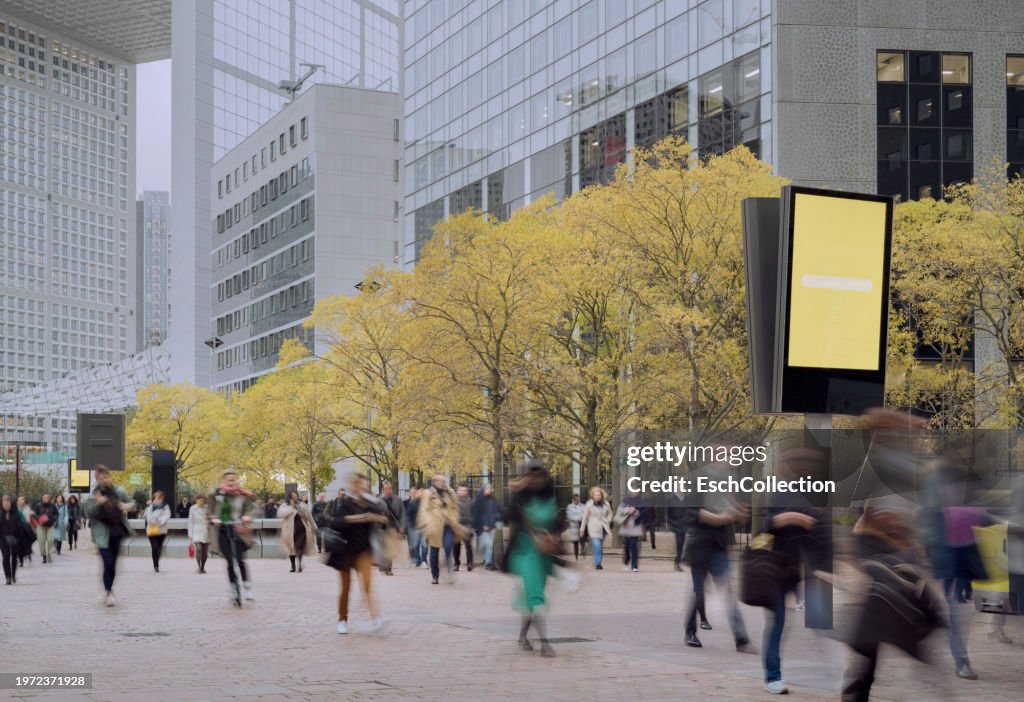 Morning commute with autumn colored trees and people arriving for work at modern business district
