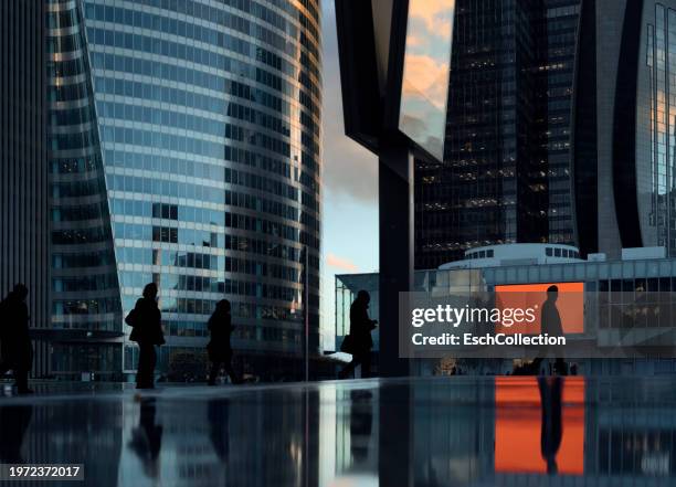afternoon commute with people passing by at pedestrian zone of modern business district - quartier financier photos et images de collection