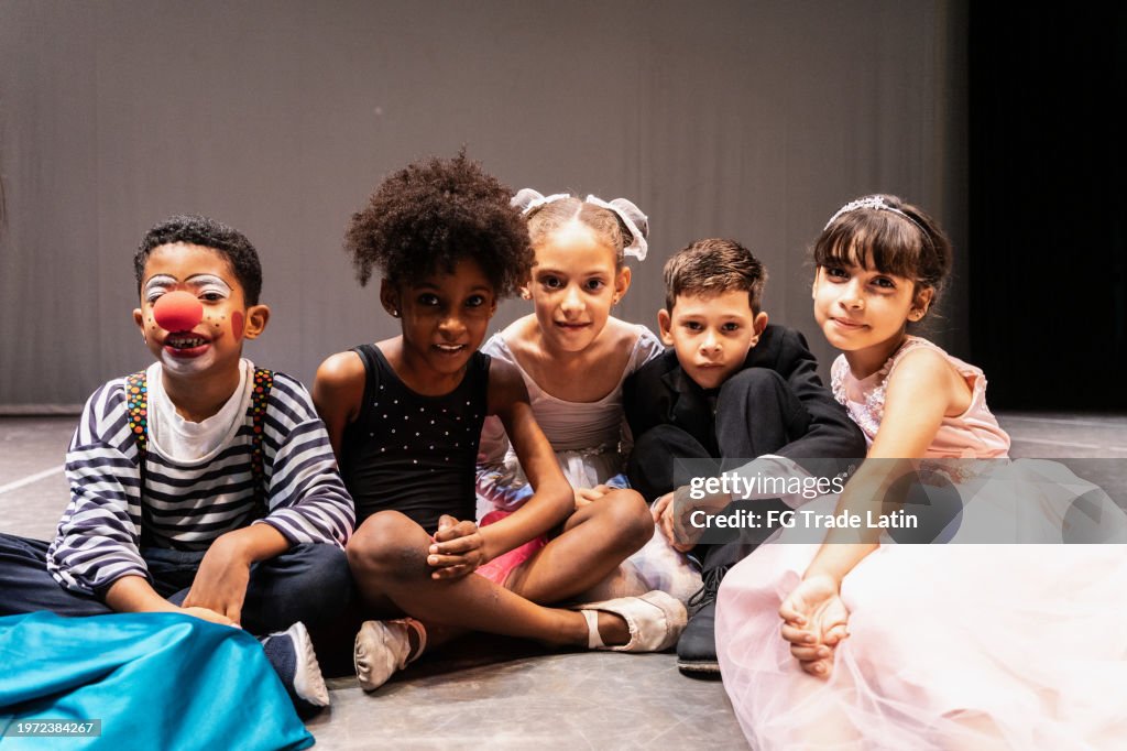 Porträt eines Kinderschauspielers, der im Bühnentheater auf dem Boden sitzt
