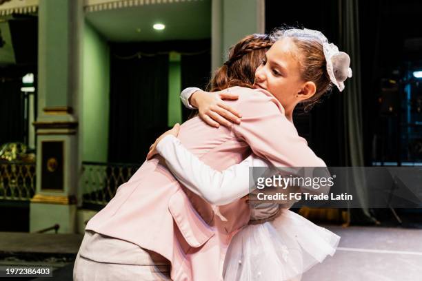 kinderballerina umarmt mutter nach aufführung im bühnentheater - we love latinos latin thespians stock-fotos und bilder