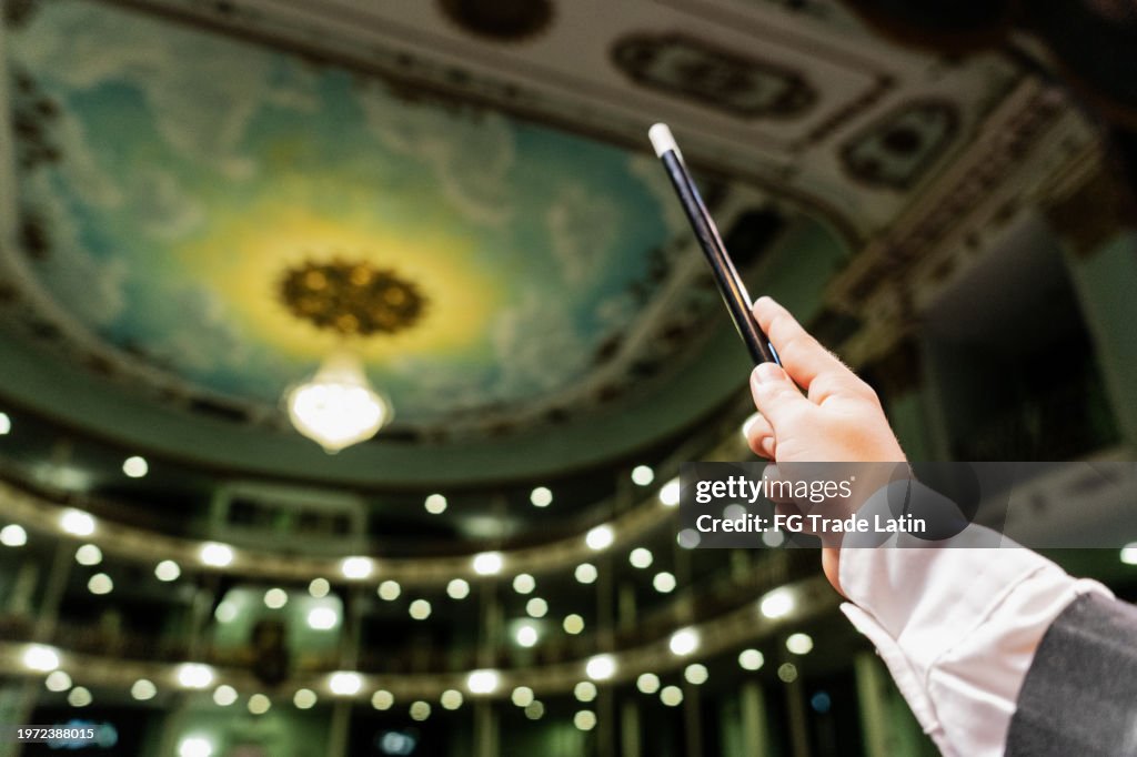 Close-up of a child magician boy holding a magic wand at stage theater