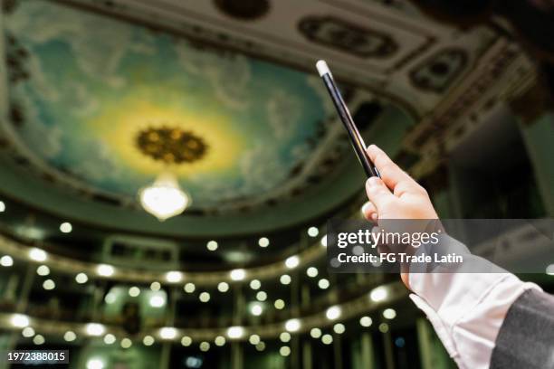 close-up of a child magician boy holding a magic wand at stage theater - magician stage stock pictures, royalty-free photos & images