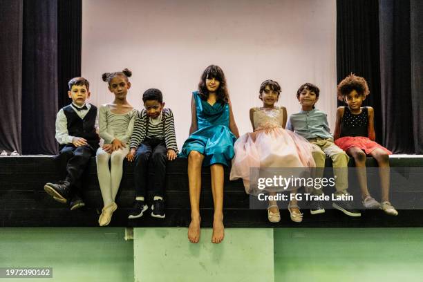 portrait of children sitting on stage theater - acting stock pictures, royalty-free photos & images