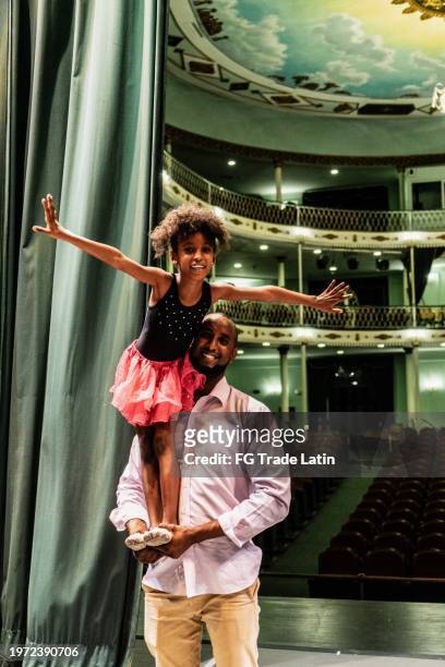 portrait of a father lifting daughter on stage theater - young artists unite stock pictures, royalty-free photos & images