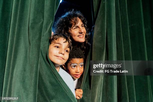 schauspieler, die das publikum durch den vorhang des bühnentheaters betrachten - bühnentheater stock-fotos und bilder