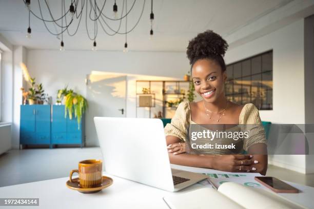 beautiful woman working on laptop in an office - afro caribbean portrait stock pictures, royalty-free photos & images