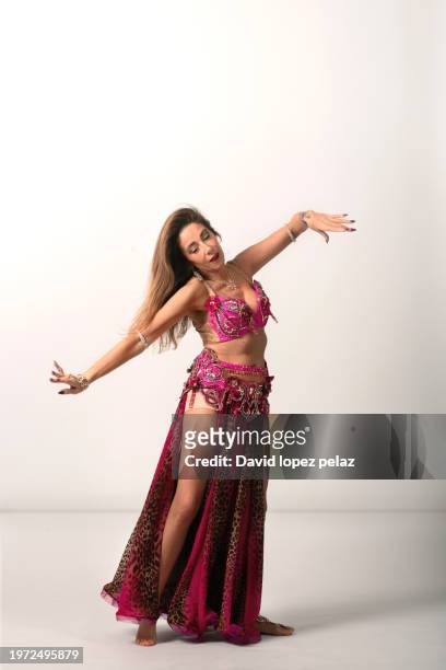 belly dancer's joyful movement in studio setting - belly dancer fotografías e imágenes de stock