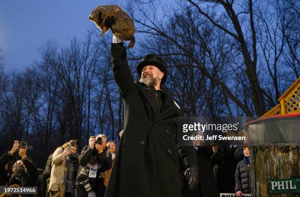 Groundhog handler AJ Dereume holds Punxsutawney Phil after he did not see his shadow predicting an early Spring during the 138th annual Groundhog Day...