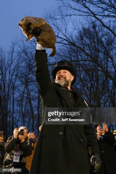 Groundhog handler AJ Dereume holds Punxsutawney Phil after he did not see his shadow predicting an early Spring during the 138th annual Groundhog Day...