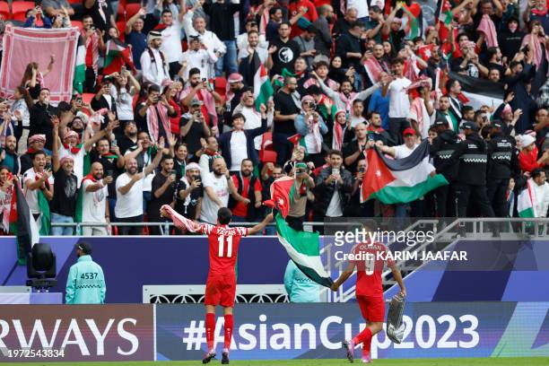 Jordan's players celebrate with the fans after their victory in the Qatar 2023 AFC Asian Cup quarter-final football match between Tajikistan and...