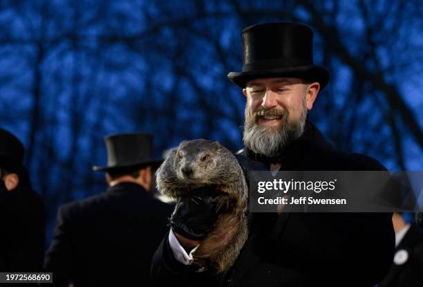 Groundhog handler AJ Dereume holds Punxsutawney Phil after he did not see his shadow predicting an early Spring during the 138th annual Groundhog Day...