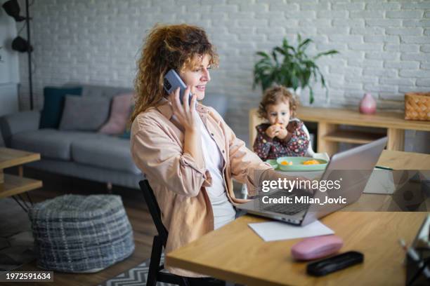 young mother working from home while taking care of her baby - hot desking stock pictures, royalty-free photos & images