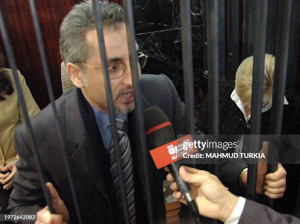 Palestinian doctor Ashraf Ahmed Juma speaks to the press from behind the bars during the final hearing in the case of infecting hundreds of Libyan...