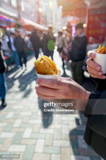 hand holding korean street food - hotteok. - busan stock pictures, royalty-free photos & images