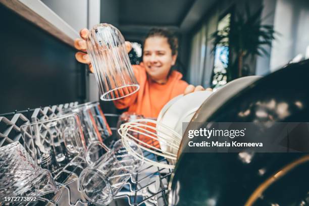 woman putting dishes in dishwasher. view from inside dishwasher. - spülmaschine stock-fotos und bilder