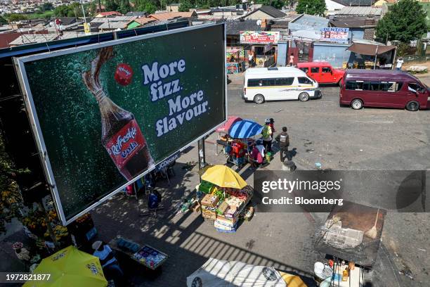 Informal market stalls under an advertising billboard by Bara taxi rank in the Soweto district of Johannesburg, South Africa, on Thursday, Feb. 1,...