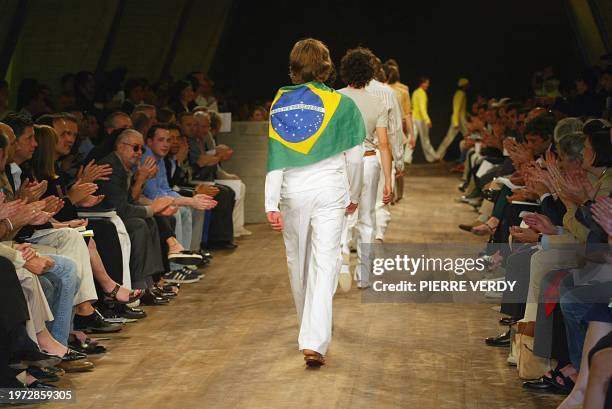 Un modèle défile avec le drapeau du Brésil sur ses épaules, le 30 juin 2002 à Paris, lors de la présentation de la collection prêt-à-porter hommes...