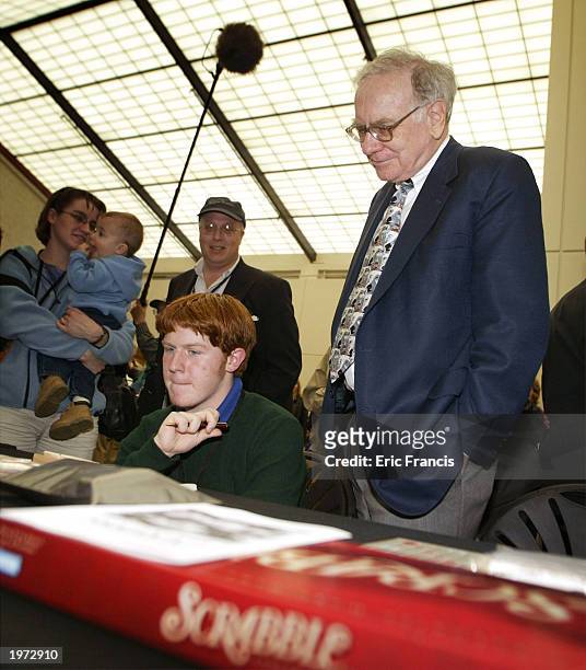 Berkshire Hathaway's CEO Warren Buffett looks on as John Calahan, of Lincoln, Nebraska, plays Peter Morris in Scrabble before a news conference May...