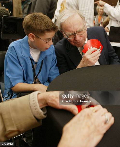 Berkshire Hathaway's CEO Warren Buffett helps Stephen Comp, of Irvine CA, with a hand of Bridge before a news conference May 4, 2003 in Omaha,...