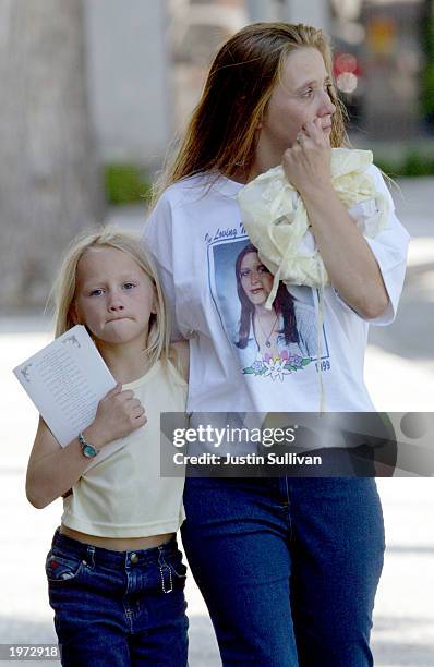 An unidentified woman cries as she and a young girl leave a memorial service for Laci Peterson and her unborn son Connor May 4, 2003 in Modesto,...