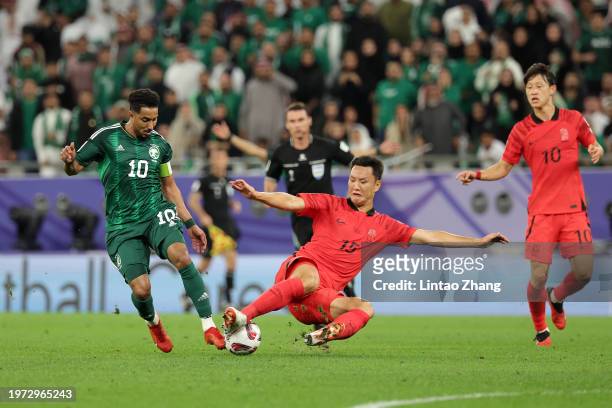 Salem Al Dawsari of Saudi Arabia and Jung Seung-Hyun of South Korea compete for the ball during the AFC Asian Cup Round of 16 match between Saudi...
