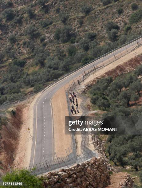 Palestinian protestors are seen walking between the fence and razor wire, part of the controversial separation barrier being built by Israel close to...