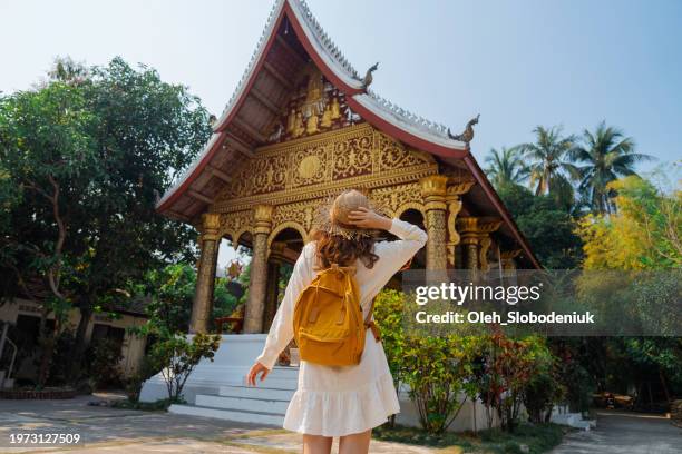 woman exploring buddhist temple in laos - luang prabang stock pictures, royalty-free photos & images