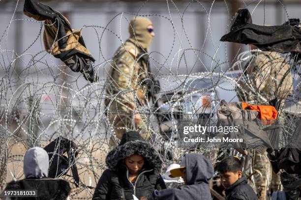 Texas National Guard troops patrol past razor wire after immigrants crossed the Rio Grande into El Paso, Texas on January 30, 2024 from Ciudad...