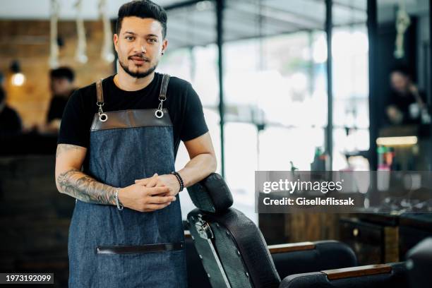 portrait of a confident young male hairstylist in salon - frisör bildbanksfoton och bilder