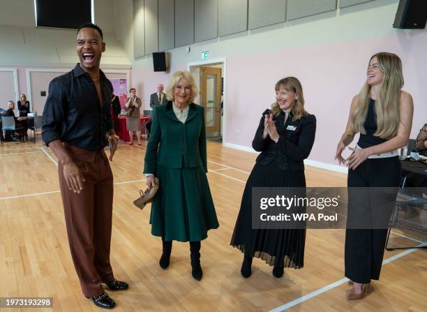 Queen Camilla, President of the Royal Voluntary Service speaks with dancer Johannes Radebe, a star on Strictly Come Dancing, dancer Tasha Ghouri who...