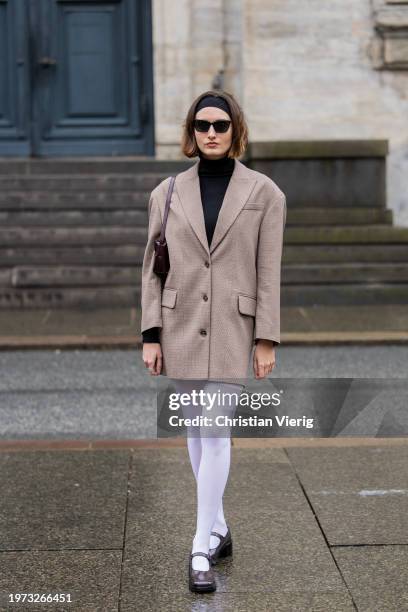 Noelia Blas wears oversized blazer, white tights outside Aeron during the Copenhagen Fashion Week AW24 on January 30, 2024 in Copenhagen, Denmark.